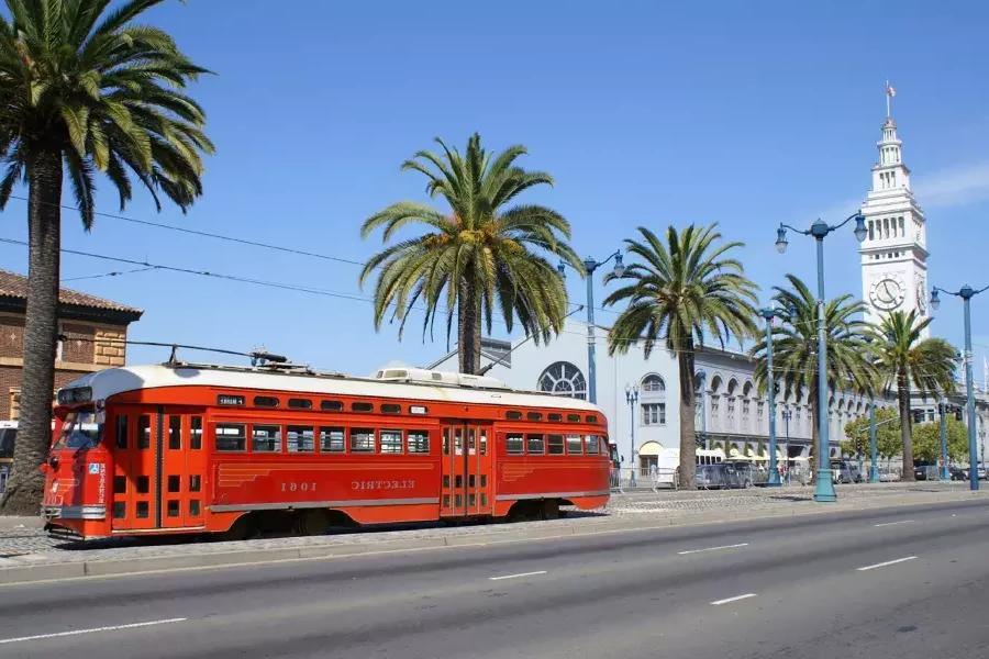 The F Line streetcar rolls down the Embarcadero in front of the 渡口.